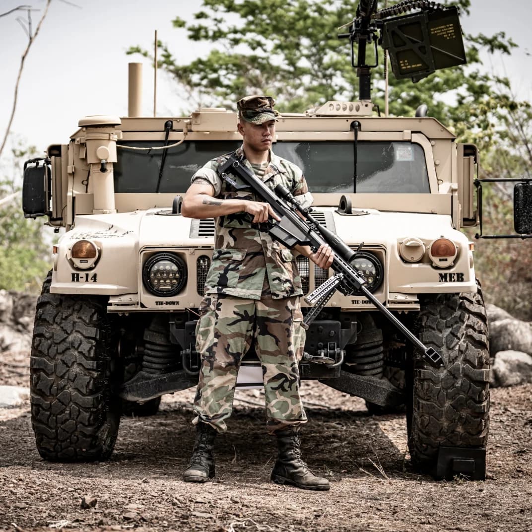 Military vehicle with soldier standing in front