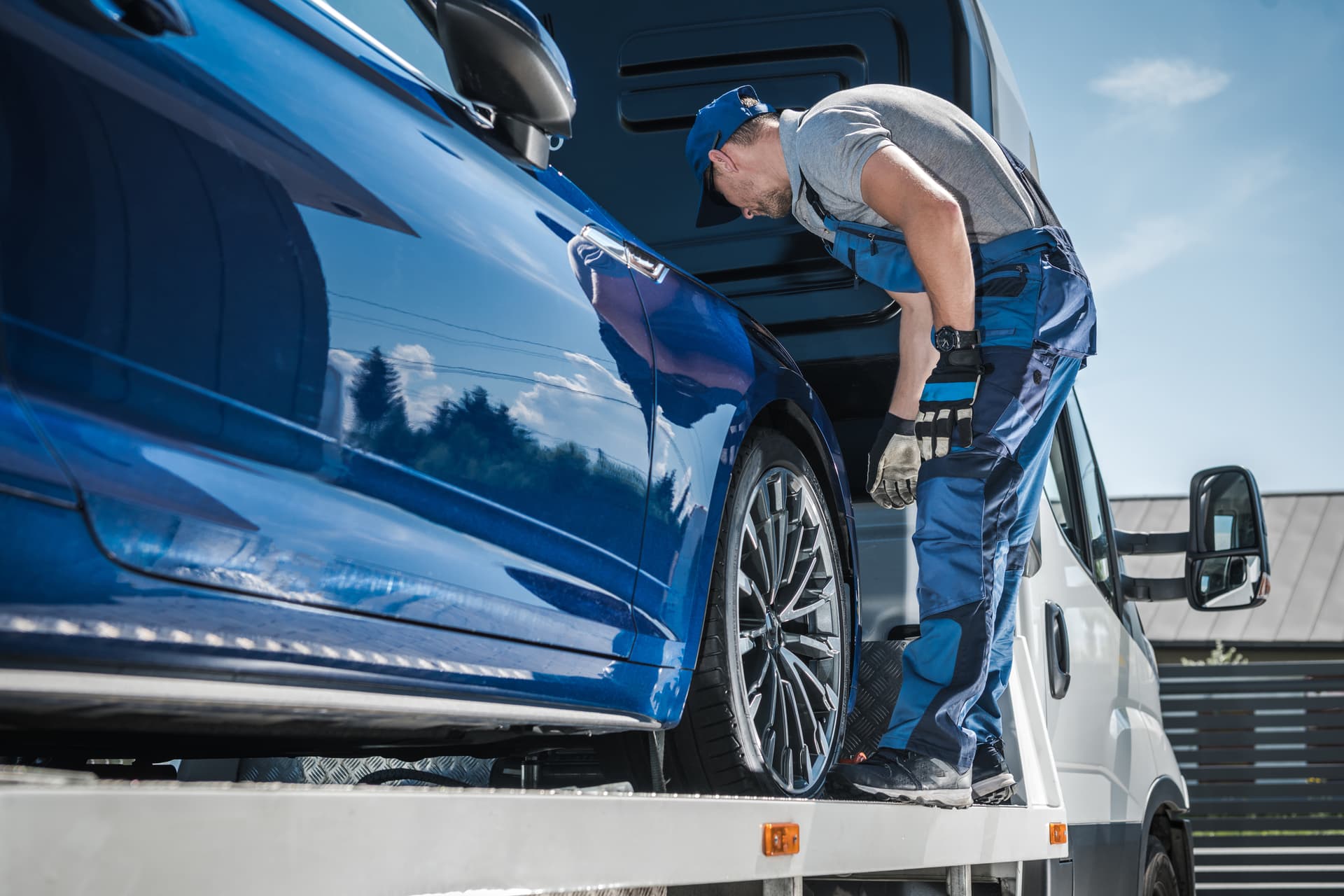 man checking loaded car hauler