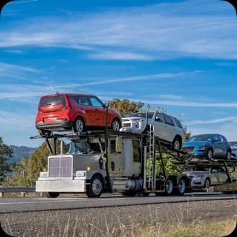 Cars shipped in a double-decker truck on road