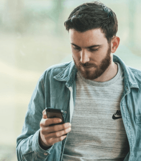 A man browsing his phone for car transport services