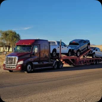 Three Cars being hauled via road
