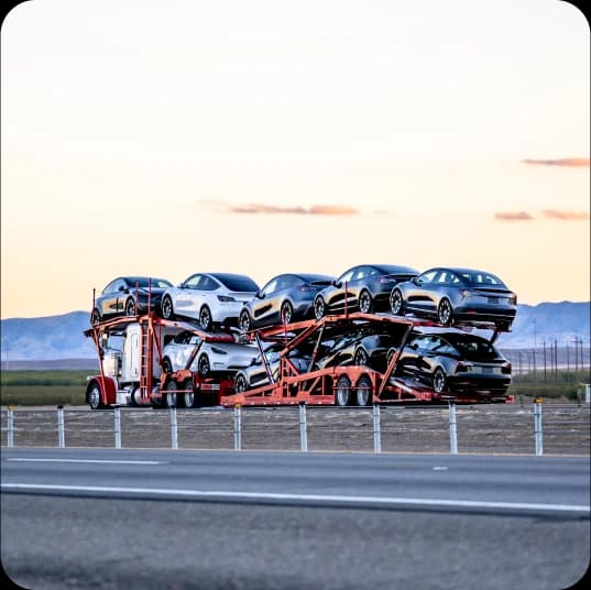 Several Cars on a carrier on road