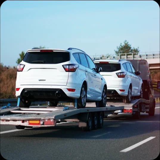 Two cars getting transported with hauler