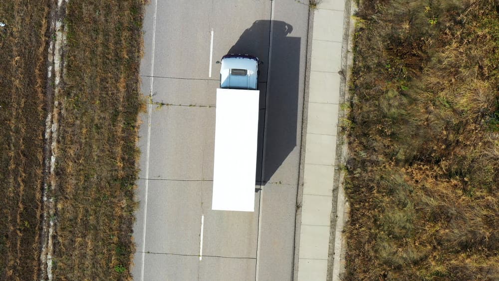 Image related to blog title Top view of a truck on a shipping route, illustrating cost-efficient car shipping and transport logistics